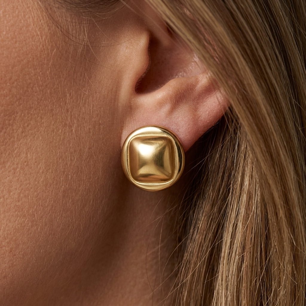 button stud earrings chunky gold button stud earrings with rounded square design worn on ear modern statement jewelry