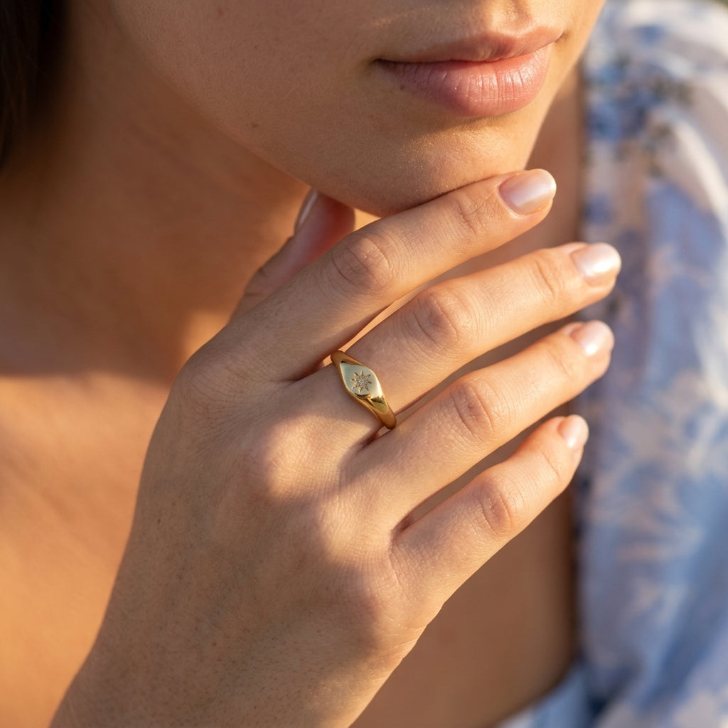celestial gold signet ring for women featuring a sparkling north star design on a polished gold surface styled on a model for chic everyday wear