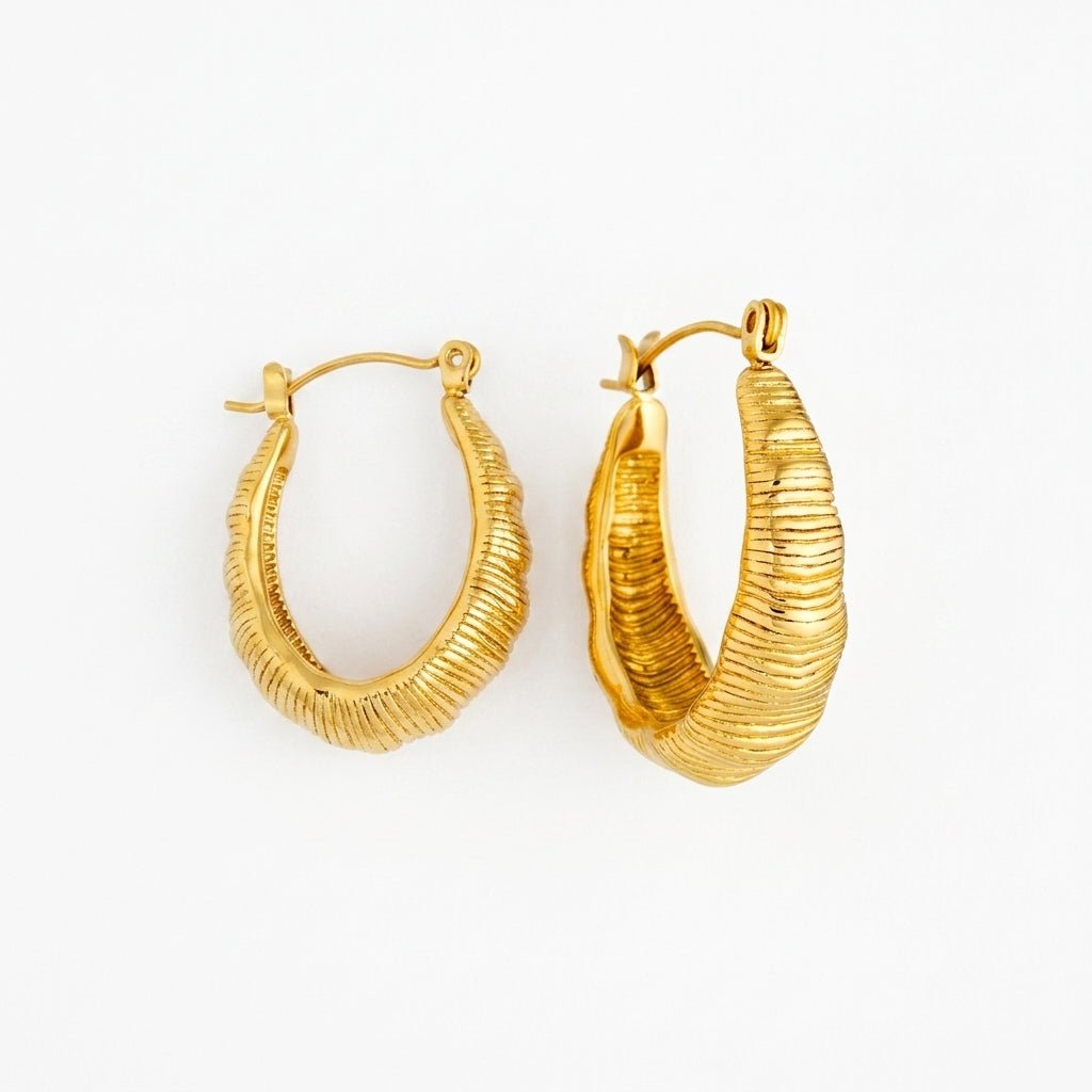 chunky gold dome earrings featuring a curved sculptural hoop design