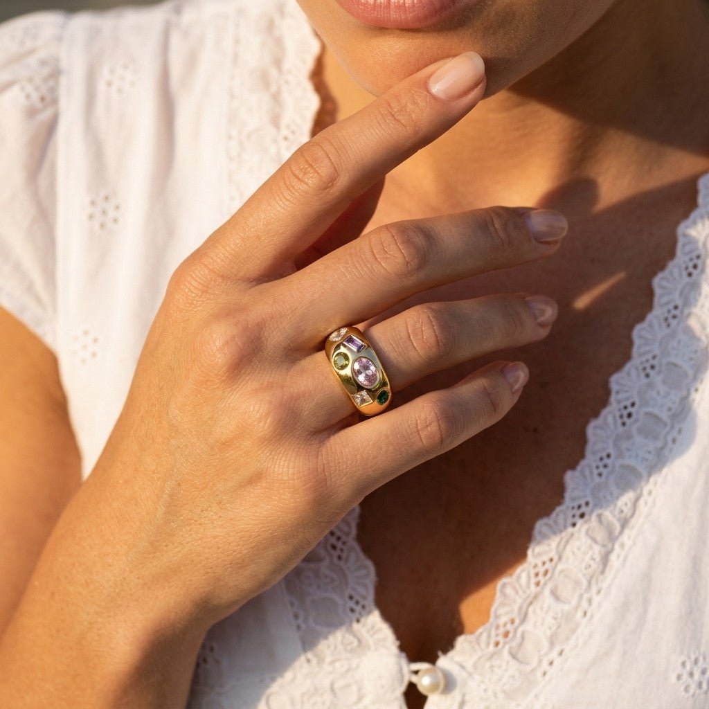 colorful stone gold ring with mixed shape gemstones set across a bold polished band
