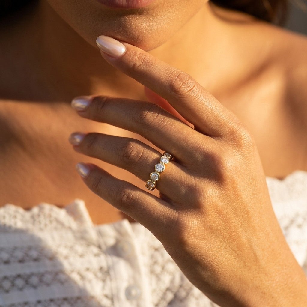 cubic zirconia band with round bezel set stones on a gold ring