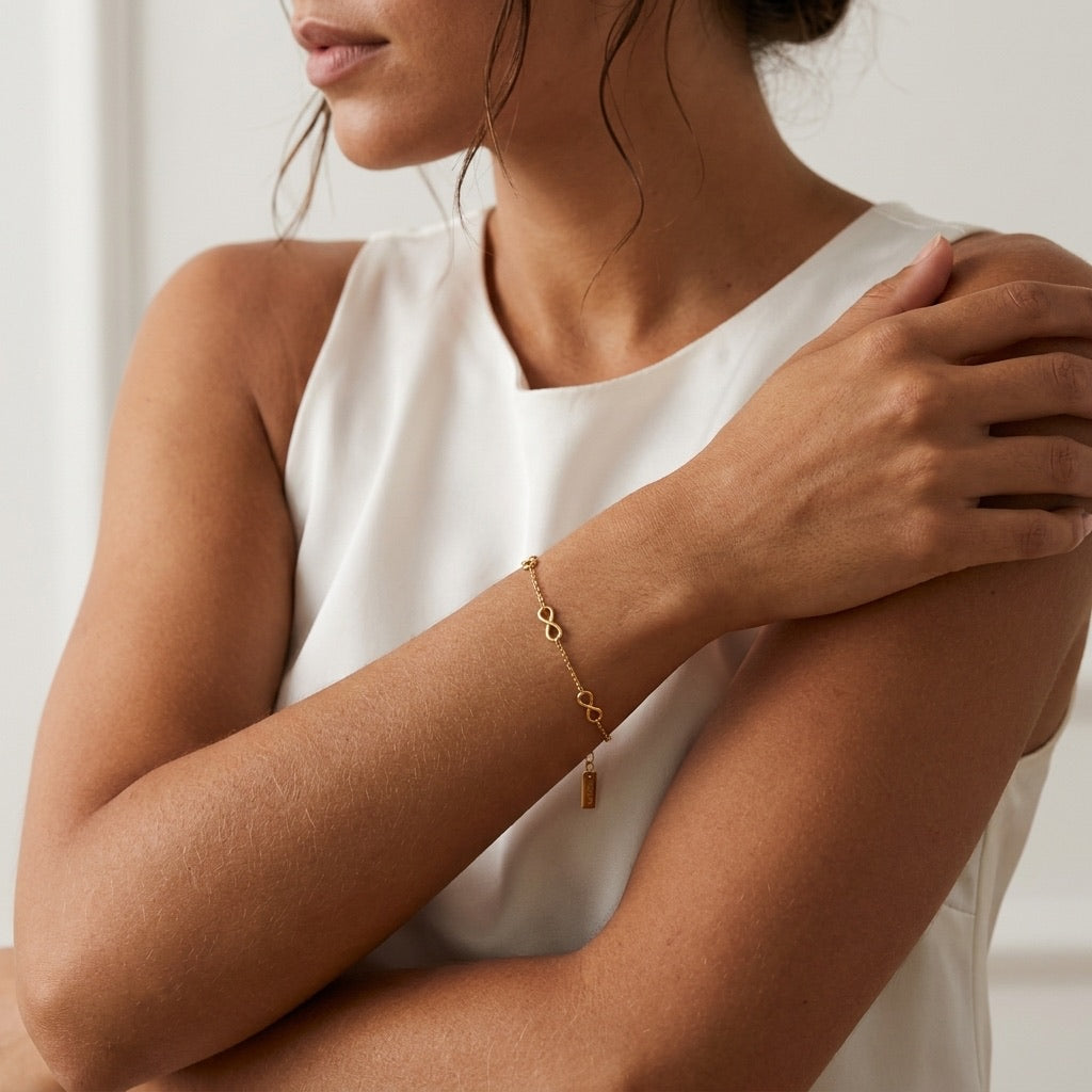 dainty gold infinity bracelet featuring small polished infinity symbols spaced along a delicate chain for timeless feminine jewelry
