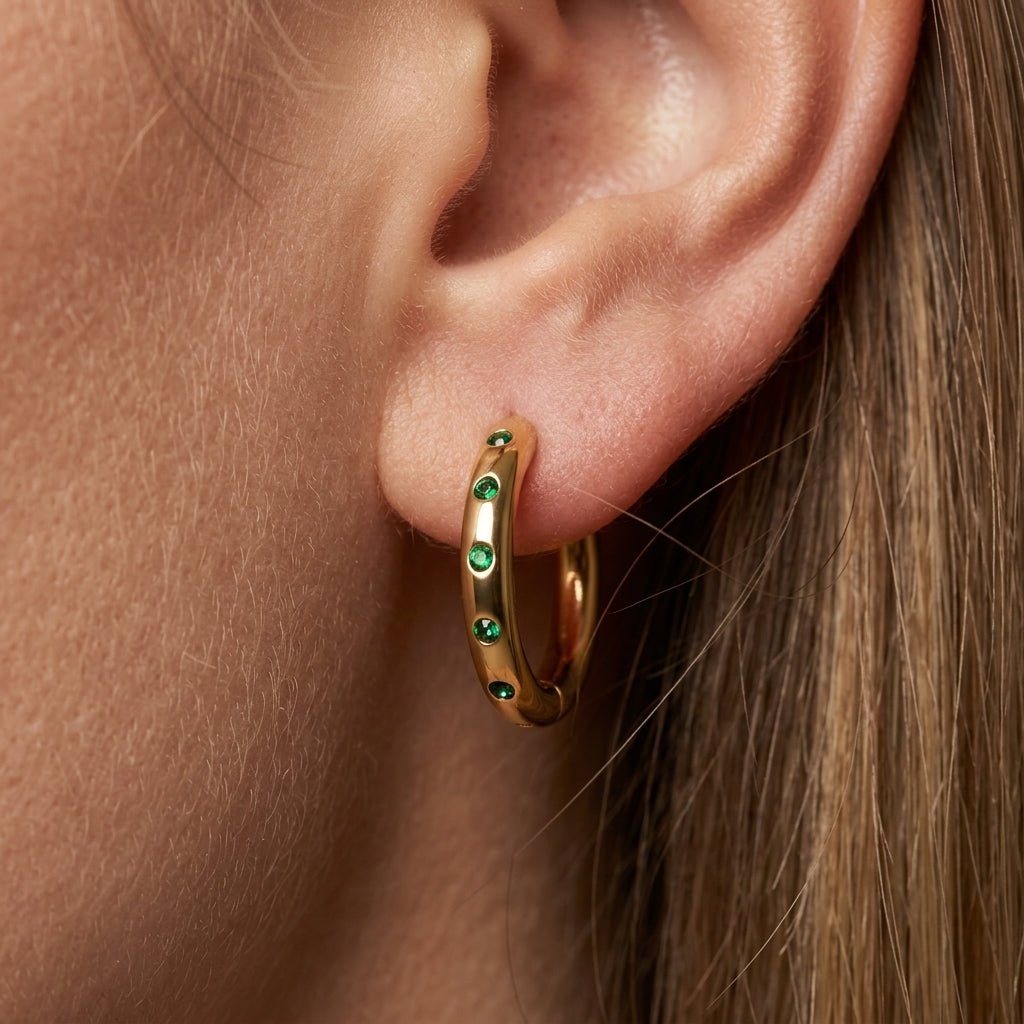 earrings gold and green sleek gold hoop earrings accented with delicate green crystal stones, blending a clean modern shape with subtle color detail for an effortlessly elegant and contemporary jewelry look