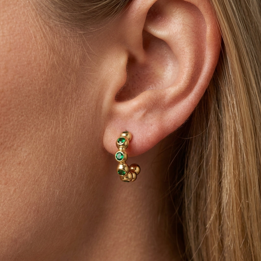 gold and emerald green earrings dainty gold huggie earrings adorned with vibrant emerald green gemstones and polished bead detailing, offering a chic contemporary style with a subtle vintage-inspired touch perfect for everyday elegance and elevated stacking looks