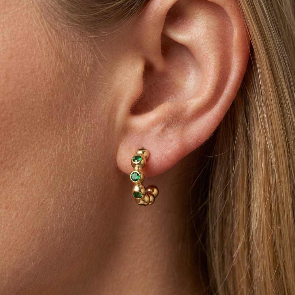 gold and emerald green earrings dainty gold huggie earrings adorned with vibrant emerald green gemstones and polished bead detailing, offering a chic contemporary style with a subtle vintage-inspired touch perfect for everyday elegance and elevated stacking looks