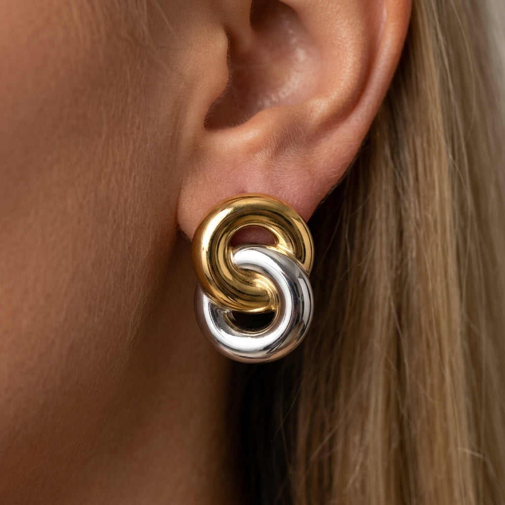 gold and silver stud earrings interlocking mixed metal earrings with bold sculptural design contemporary statement jewelry retro inspired style