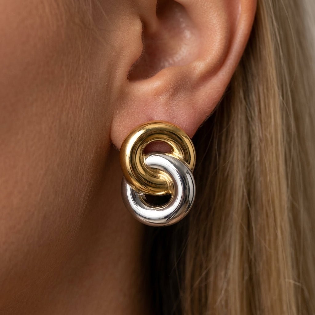 gold and silver stud earrings interlocking mixed metal earrings with bold sculptural design contemporary statement jewelry retro inspired style