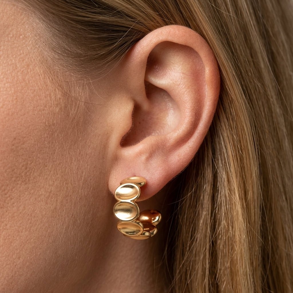gold bubble hoop earrings, polished gold huggie earrings worn on ear with rounded bubble detailing, bold contemporary statement jewelry inspired by modern beach earrings design