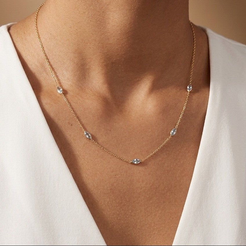 gold crystal station necklace with evenly spaced marquise and round stones on a delicate chain