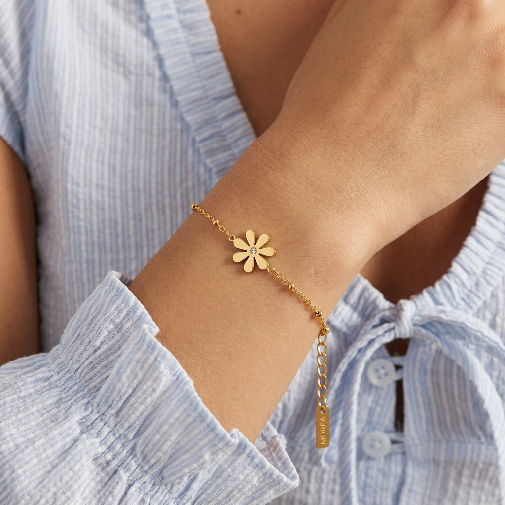 gold flower charm bracelet featuring a delicate daisy pendant with polished gold petals and a sparkling crystal center for feminine everyday jewelry