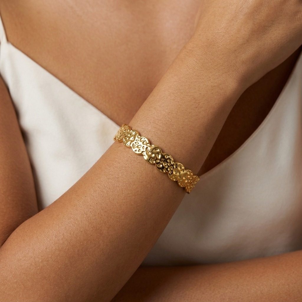 gold sculpted chain bracelet with detailed textured links and a bold statement design