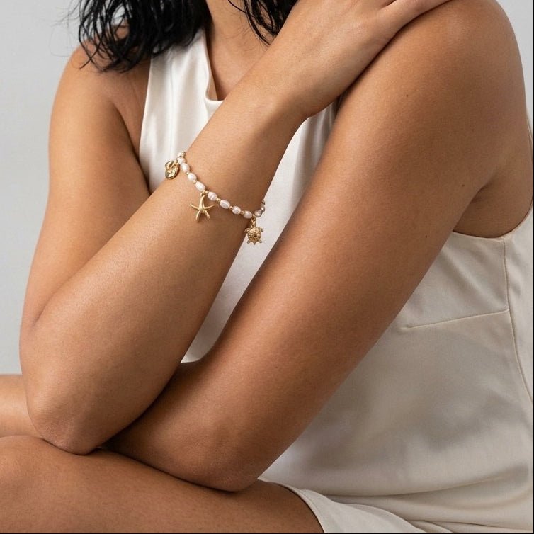 gold sea charm pearl bracelet featuring starfish turtle and whale tail charms
