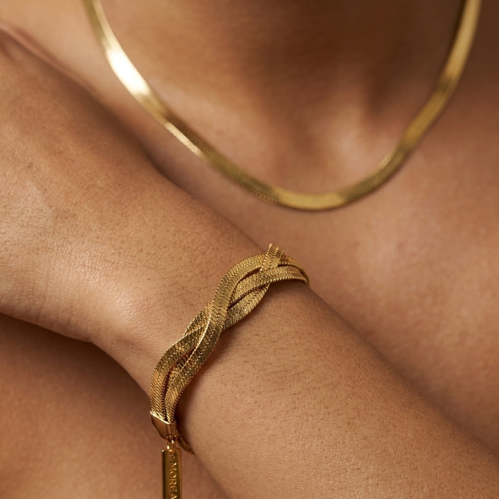 gold twisted herringbone bracelet for women featuring overlapping flat gold chains arranged in an elegant braided pattern with textured detailing