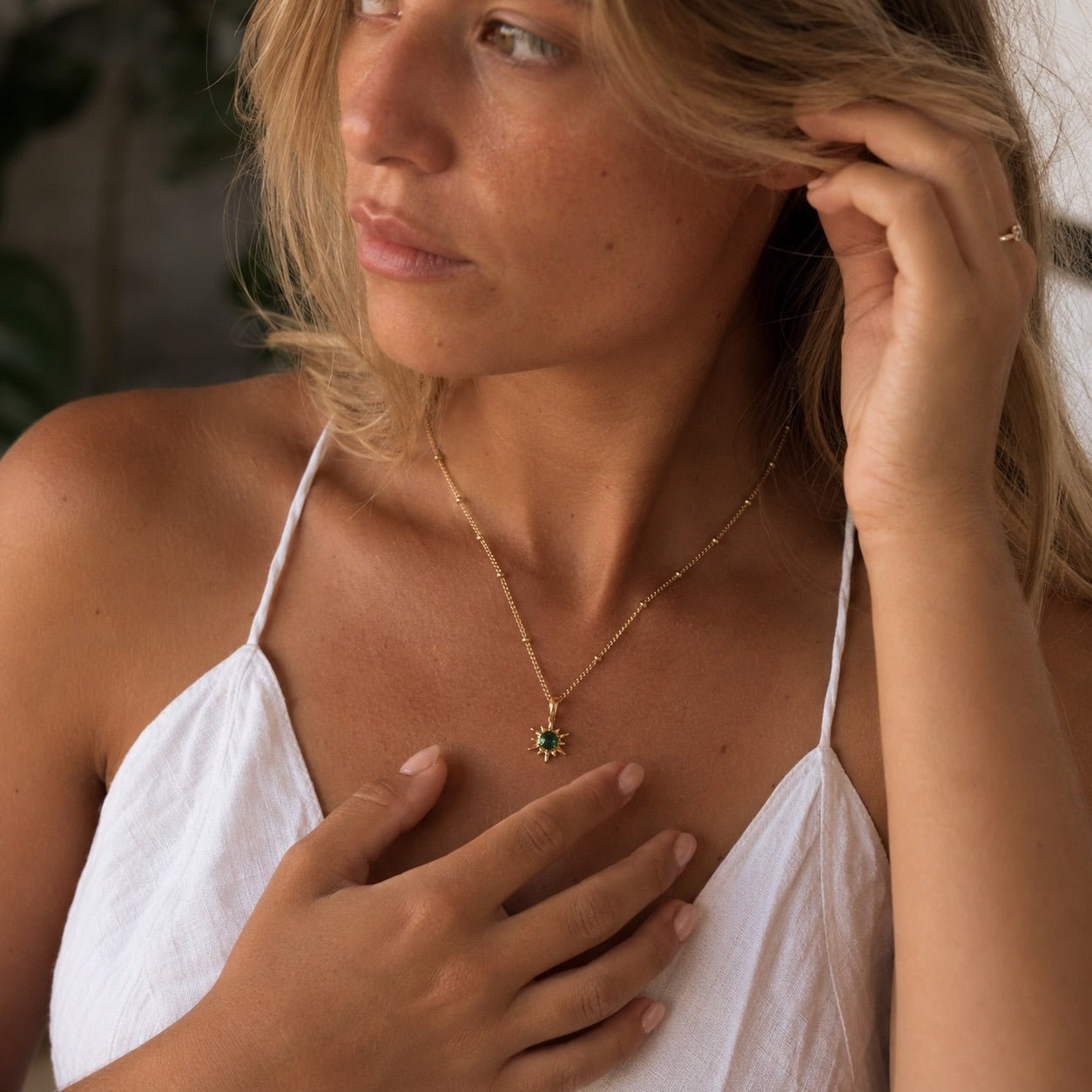 green pendant necklace with dark green gemstone