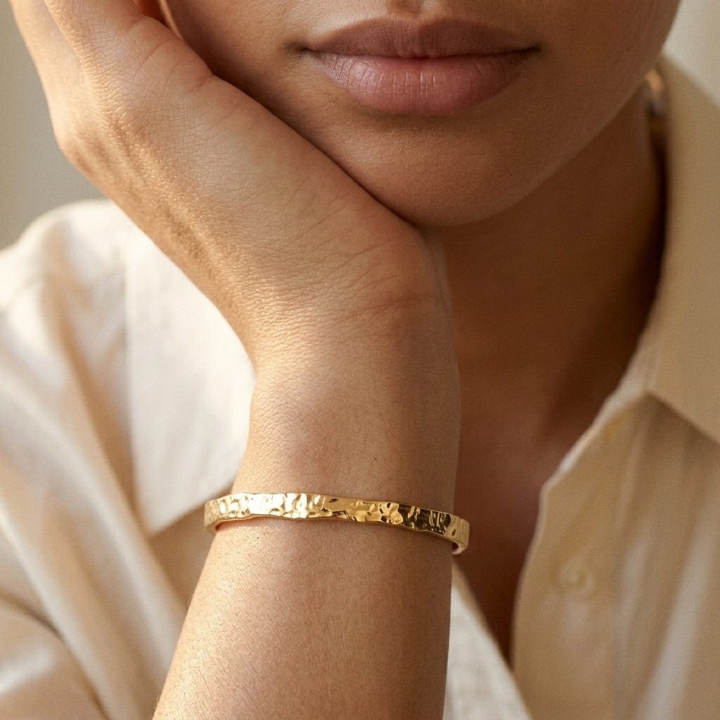 hammered gold bangle bracelet with an artisan textured surface and polished statement finish