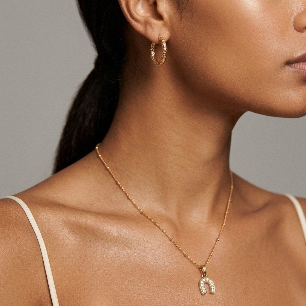 lucky horseshoe charm necklace with sparkling cubic zirconia stones and a polished gold-tone finish