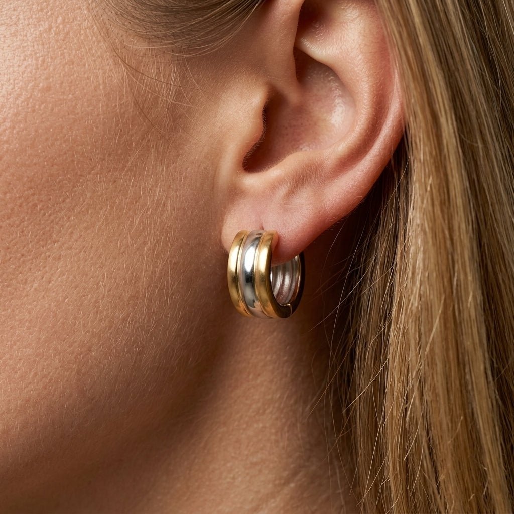 mixed metals earrings worn on ear, chunky gold and silver huggie hoop earrings for women, modern two tone statement earrings, minimalist everyday earrings