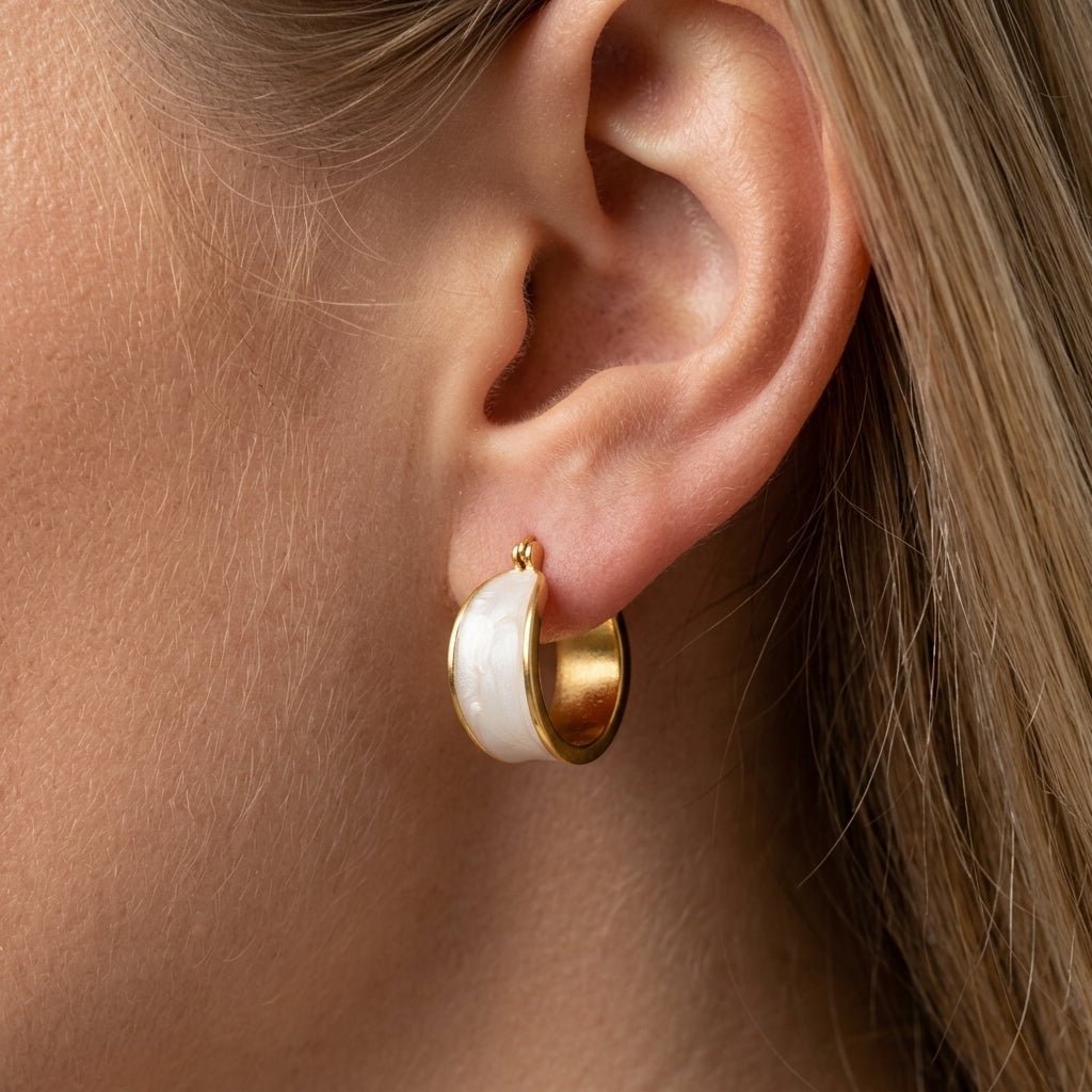 mother of pearl and gold earrings elegant gold huggie earrings featuring a smooth mother of pearl inlay with a sleek curved silhouette, combining soft natural tones with modern minimal style for a refined and timeless jewelry look