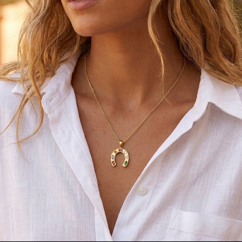 multicolor horseshoe necklace featuring rainbow stones in a polished gold pendant