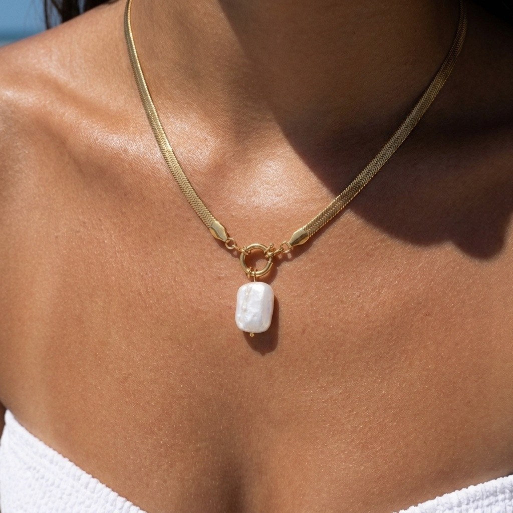 pearl charm gold choker featuring a statement pearl drop suspended from a polished gold-tone necklace