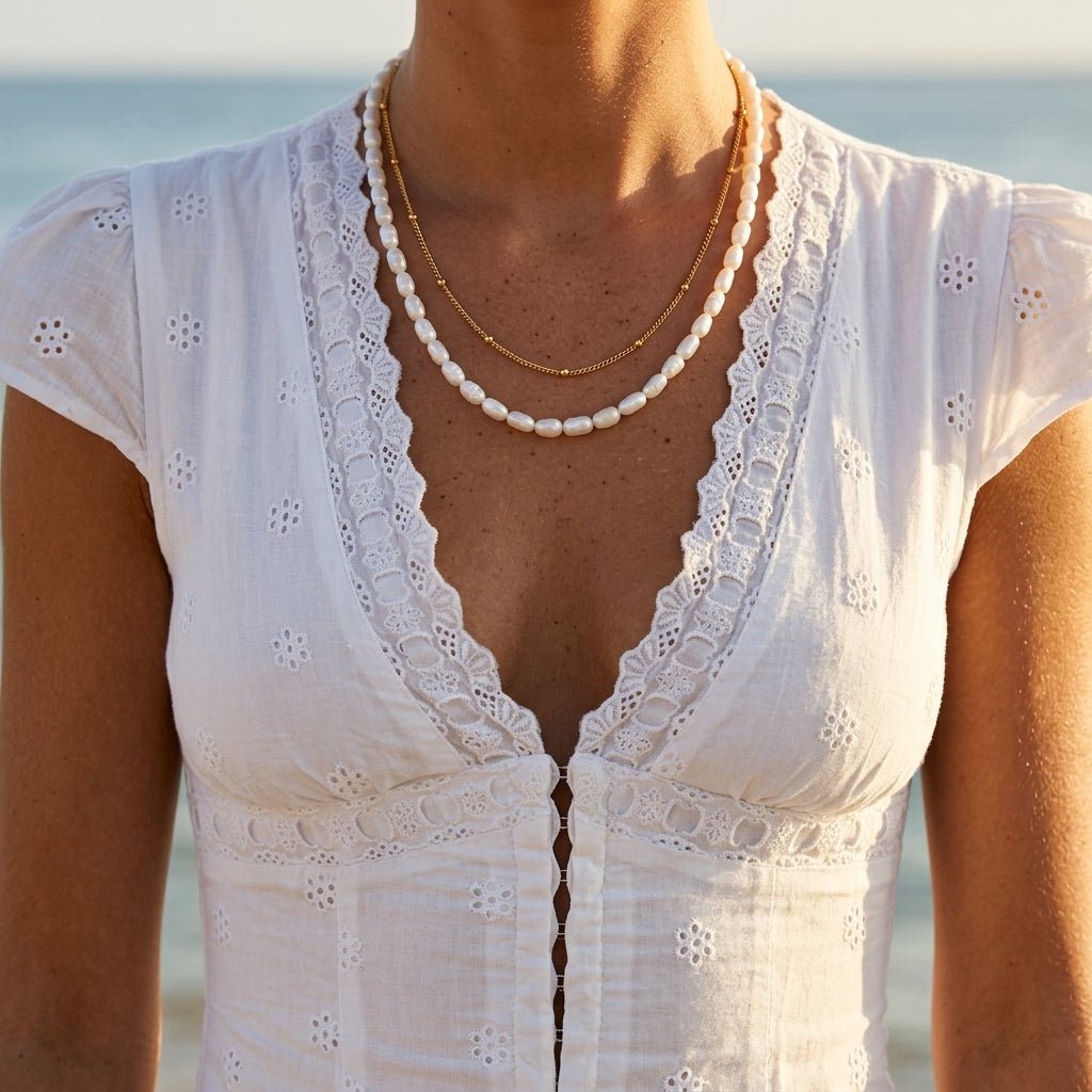 white pearl necklace worn with a delicate gold chain for a layered look