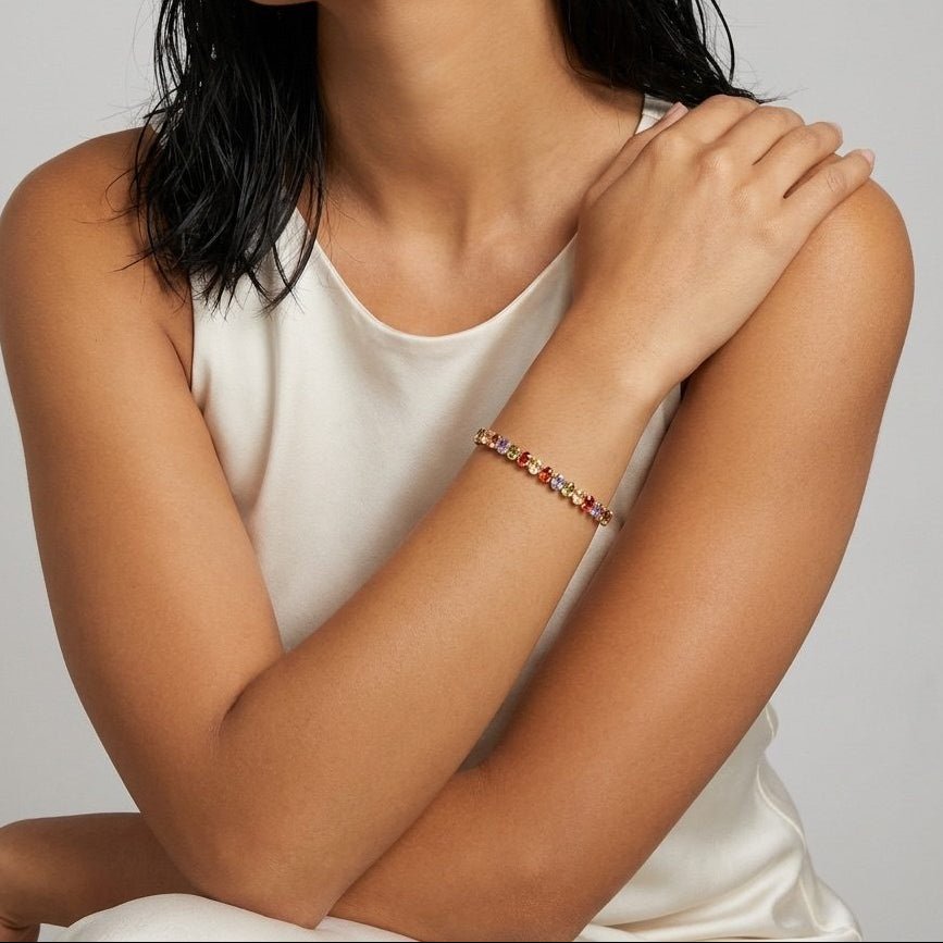 rainbow CZ tennis bracelet featuring multicolor oval cubic zirconia stones in a gold-tone setting
