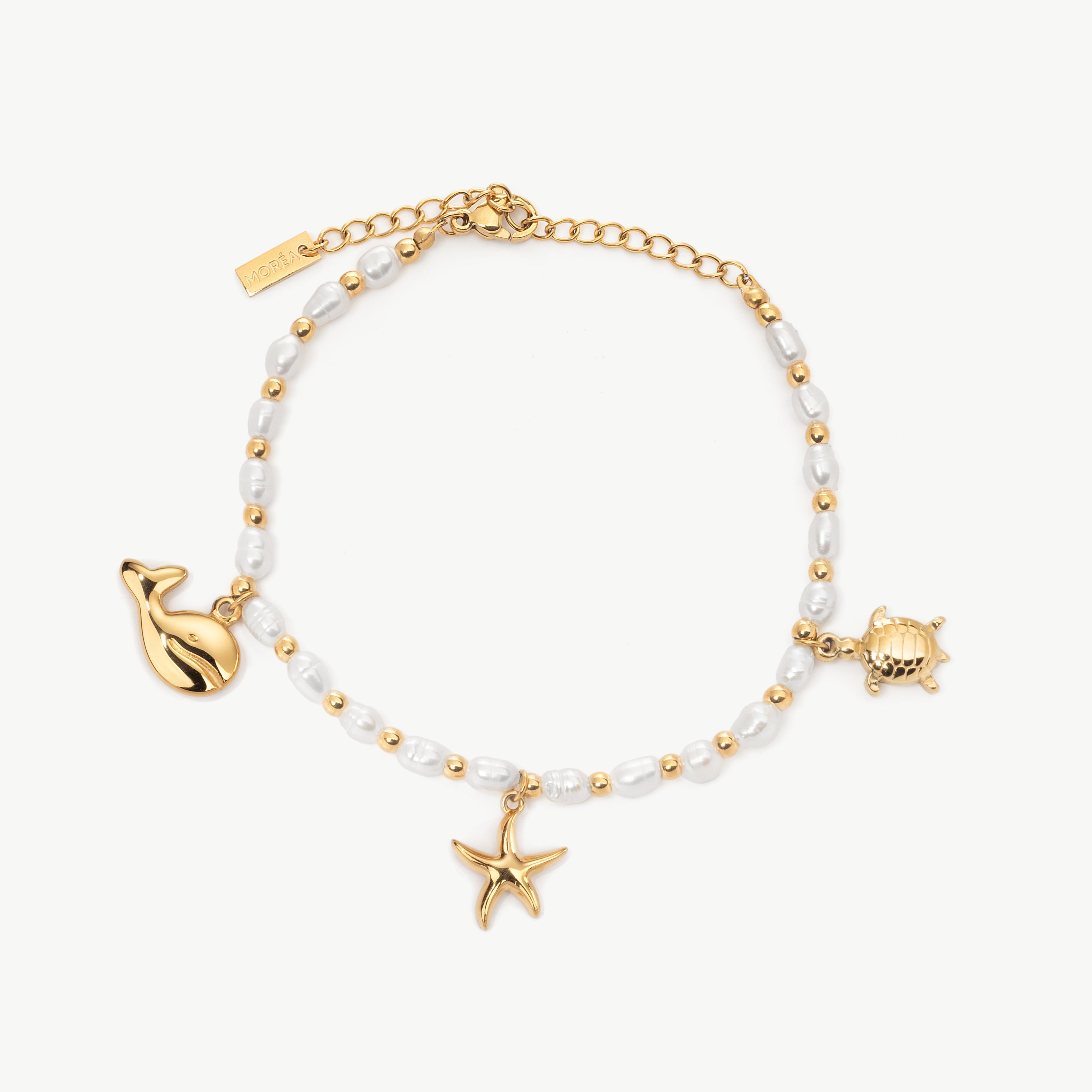 sea charm bracelet in gold with ocean themed charms, turtle charm bracelet and starfish bracelet with polished finish and coastal detail