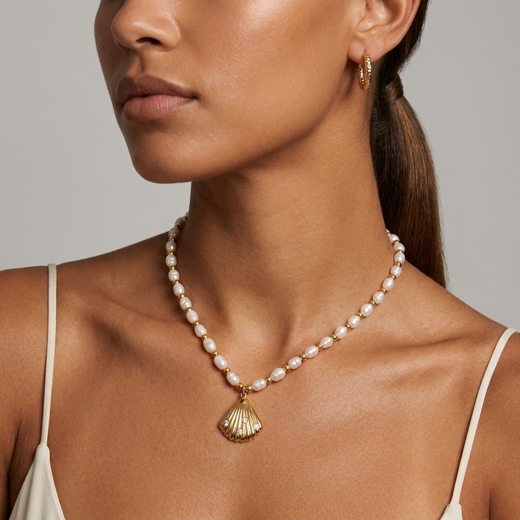 pearl necklace with gold seashell pendant and sparkling stone details