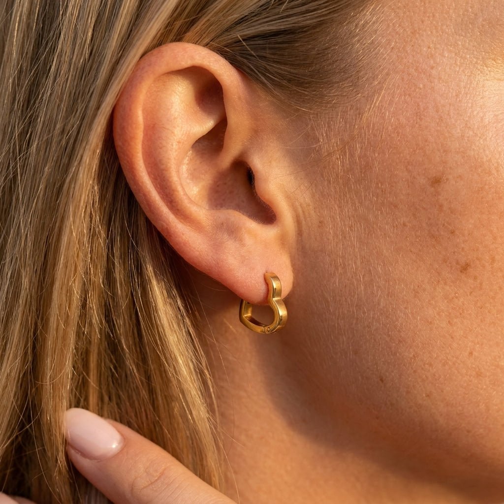 small gold heart hoop earrings with a polished heart shaped design