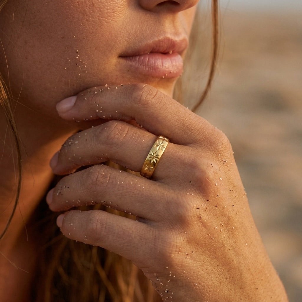 star motif gold ring with engraved celestial details and a wide polished finish
