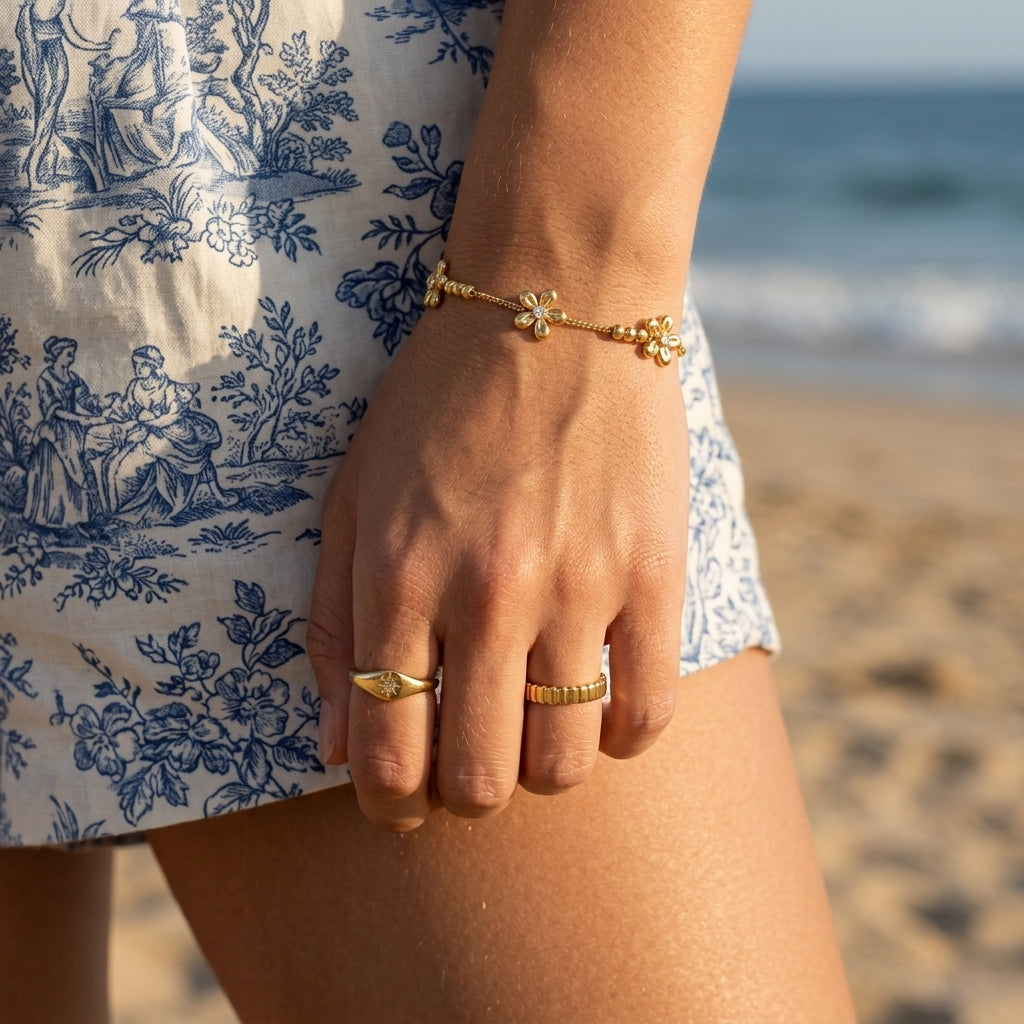 thin flower charm bracelet for women featuring delicate gold floral charms with sparkling crystal centers and polished gold beads on a fine chain for elegant everyday jewelry