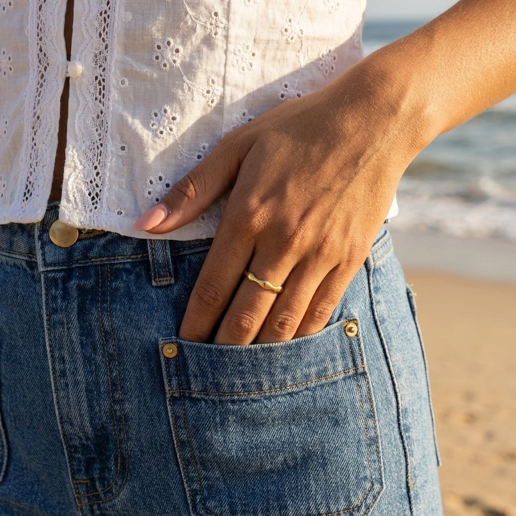 wavy gold ring with a smooth polished wave band, worn on hand for a minimalist everyday look
