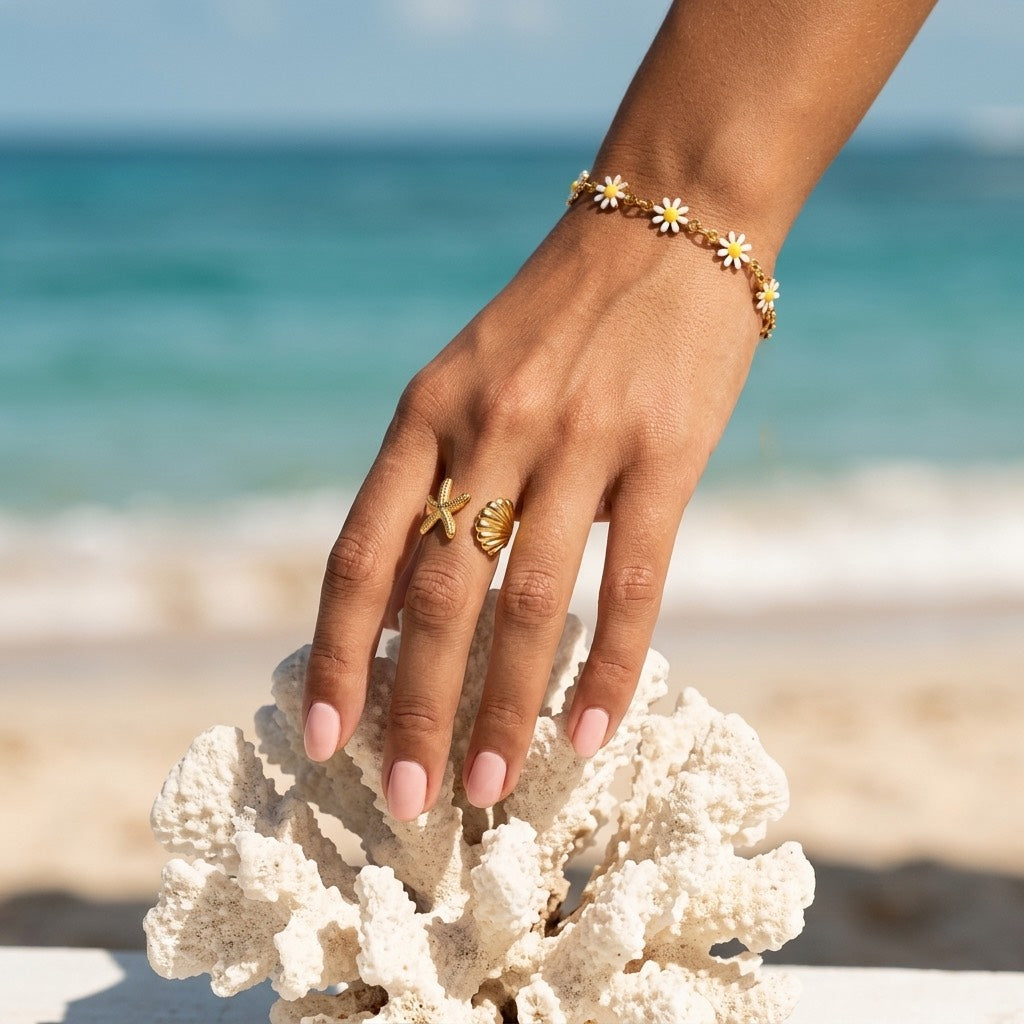white daisy charm bracelet featuring multiple white enamel flower charms with sunny yellow centers and polished gold links for playful floral jewelry