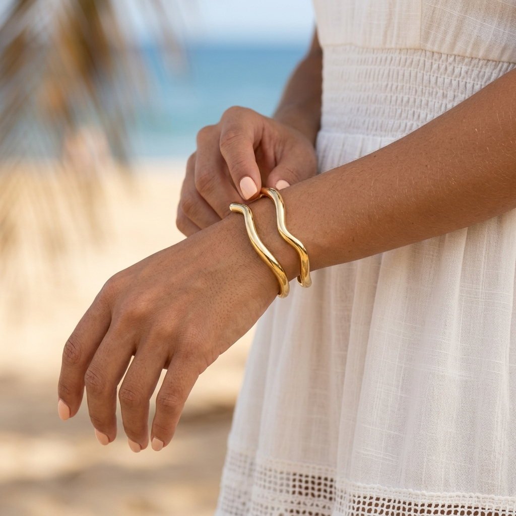 women's gold sculptural bangle bracelet featuring an elegant fluid wave design
