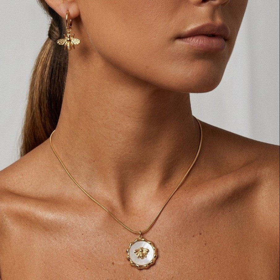 bee medallion gold necklace with an elegant white centerpiece and gold bee design