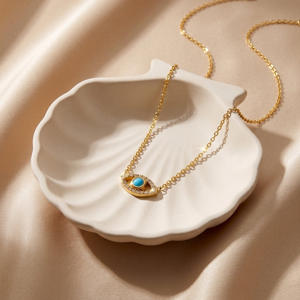 gold charm necklace featuring a turquoise colored center and sparkling accents styled on a model at a marina for a timeless coastal look
