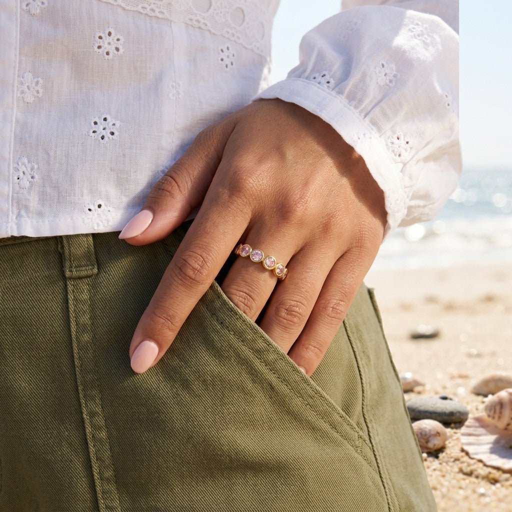 blush stone ring with round bezel set stones on a gold band