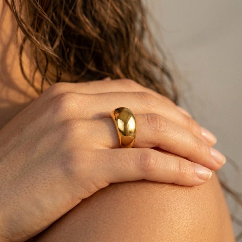 bold gold band with a high polish finish and chunky sculpted profile, styled on hand