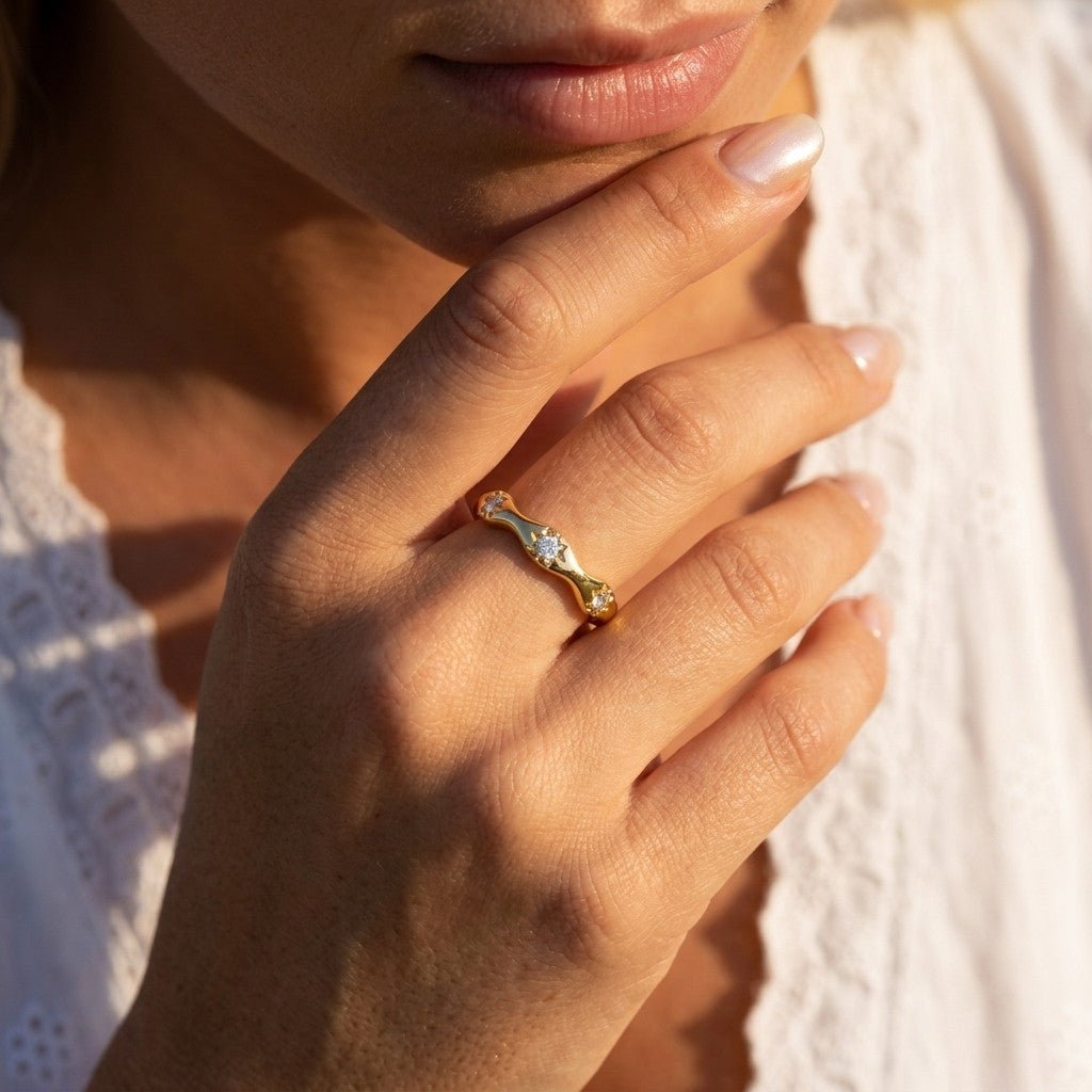 celestial star band with sparkling stone set motifs and a delicate polished gold finish