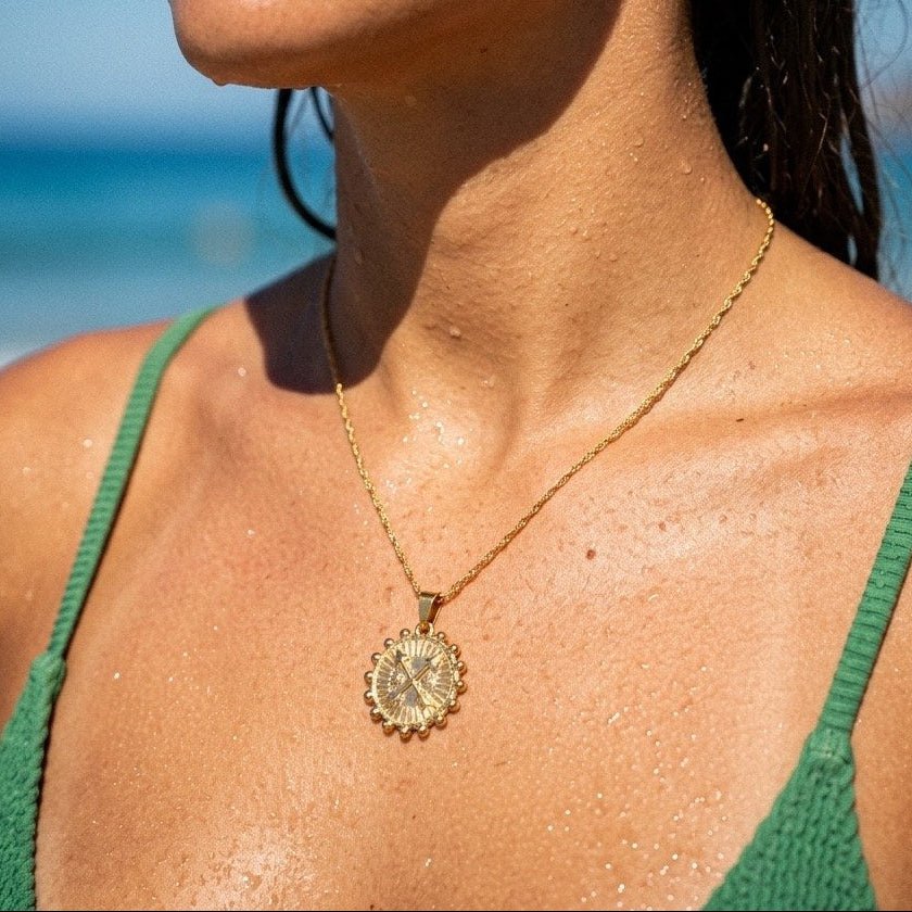 compass pendant necklace with an ornate gold-tone medallion inspired by travel and exploration