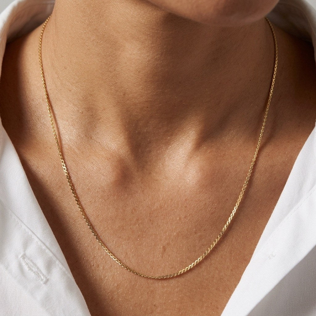 delicate gold curb necklace with a slim interlocking chain and understated finish
