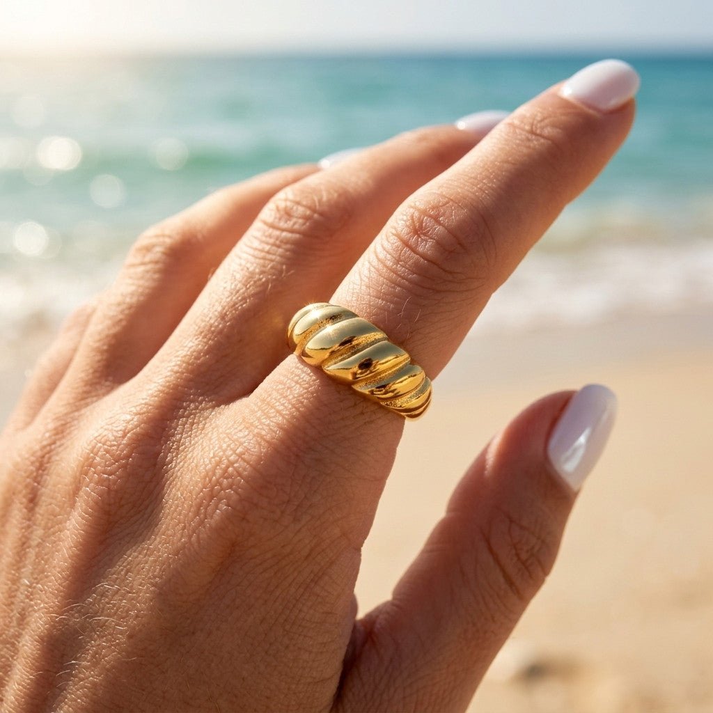 domed ribbed ring in polished gold with a chunky curved profile, worn on hand