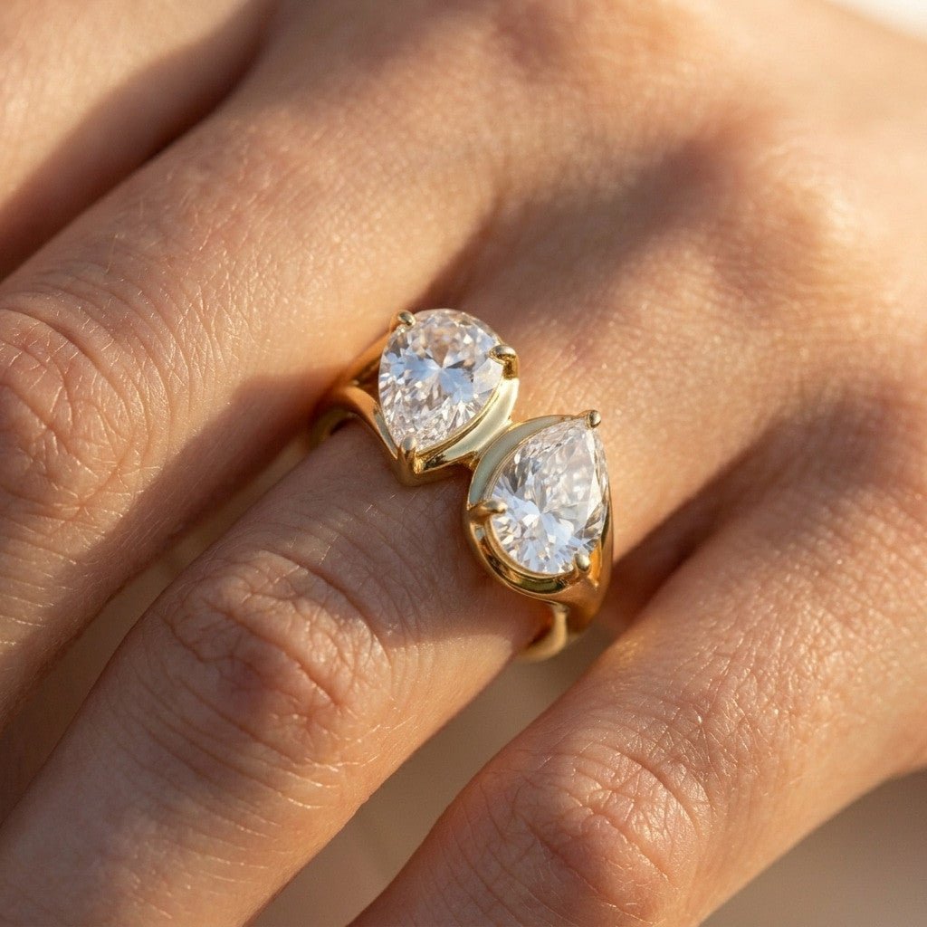 double pear ring with two sparkling pear shaped stones and a polished gold setting