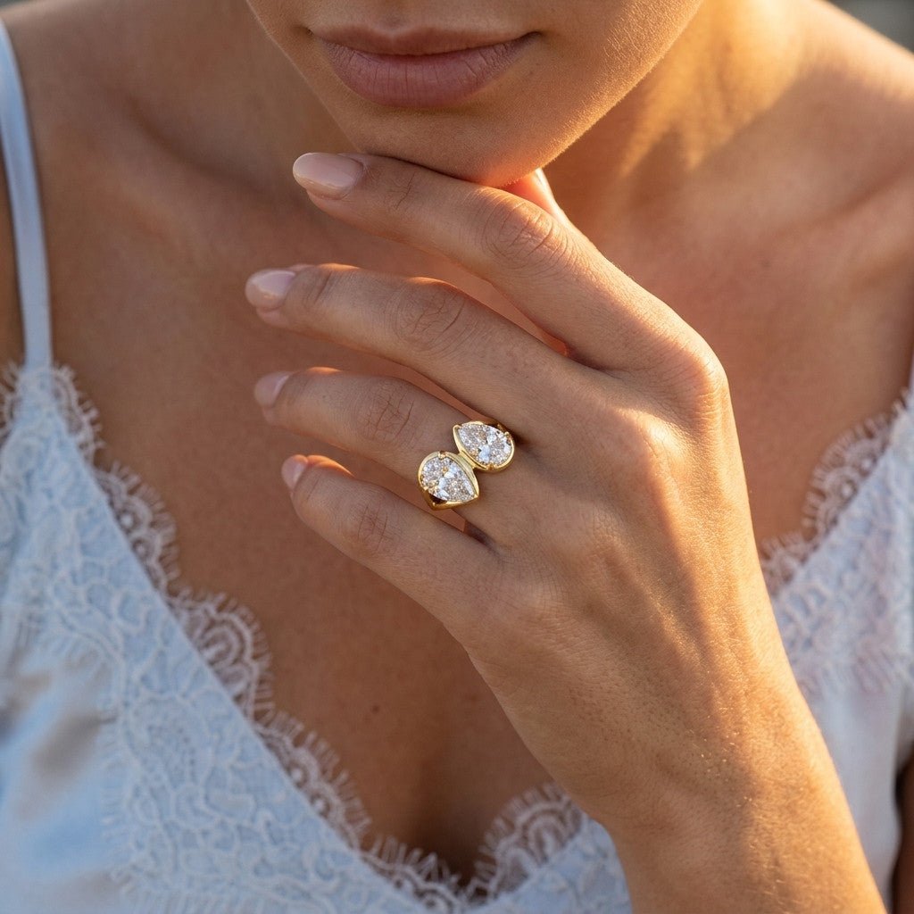 double stone gold ring with two pear cut stones and a bold polished finish
