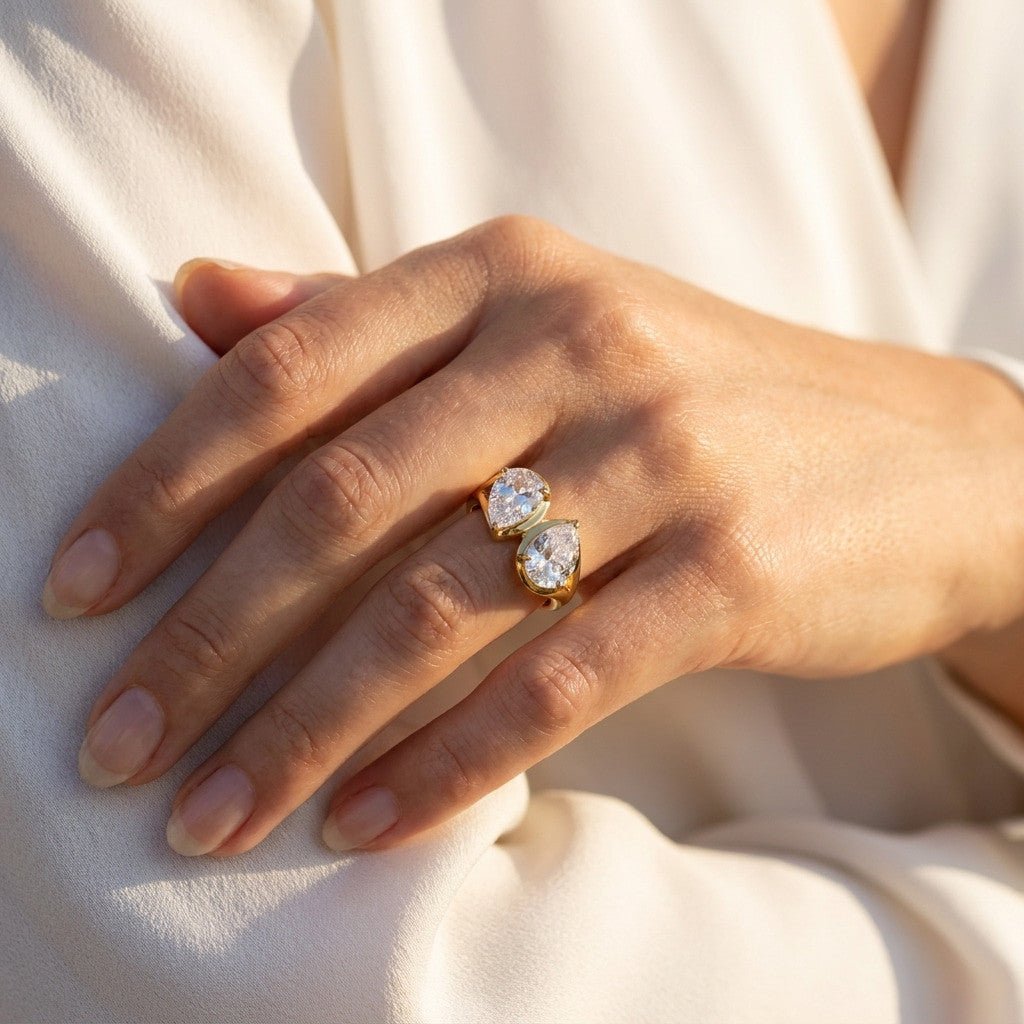 double stone gold ring with sparkling pear shaped stones in an open band design