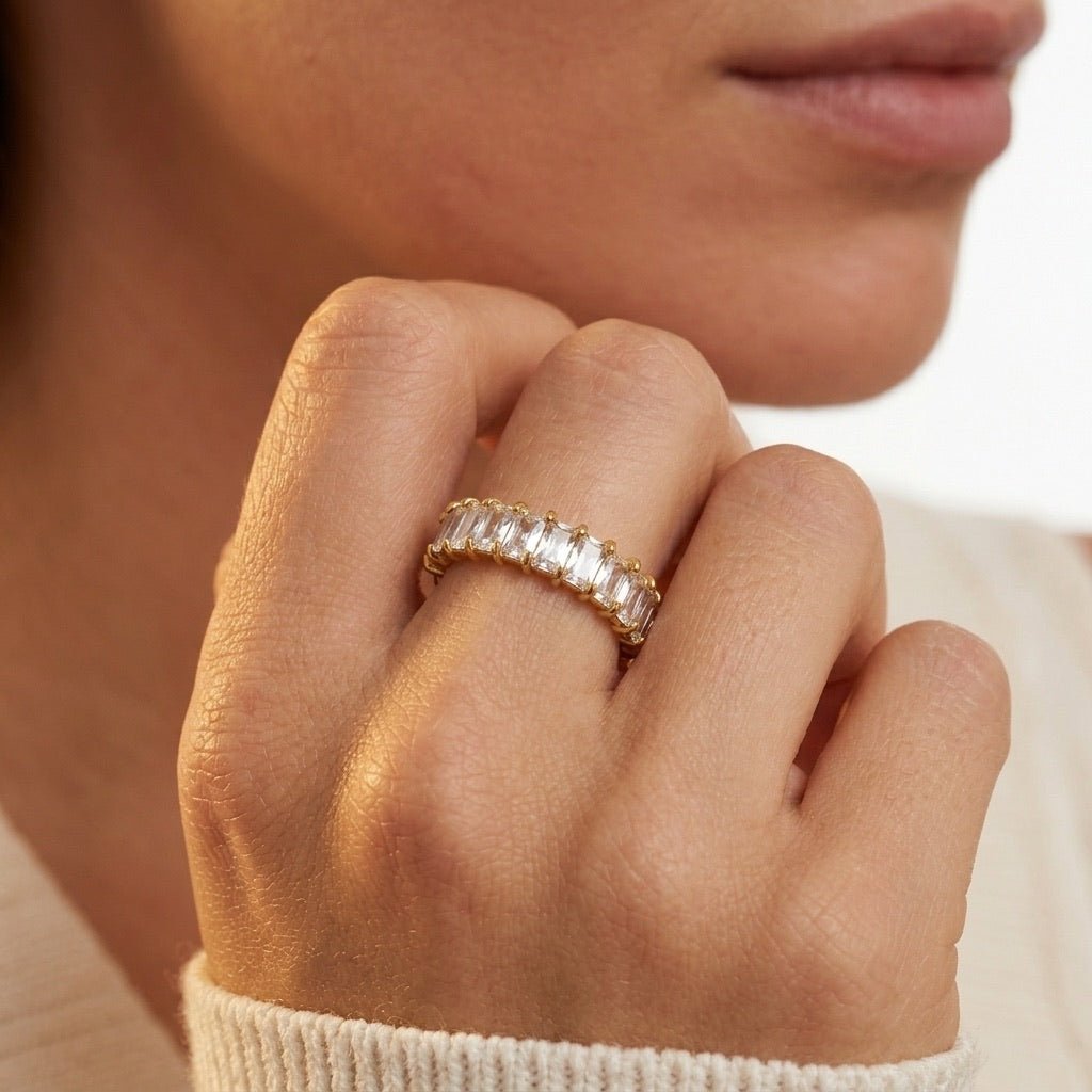 eternity style band with a row of rectangular cubic zirconia stones and polished gold detailing