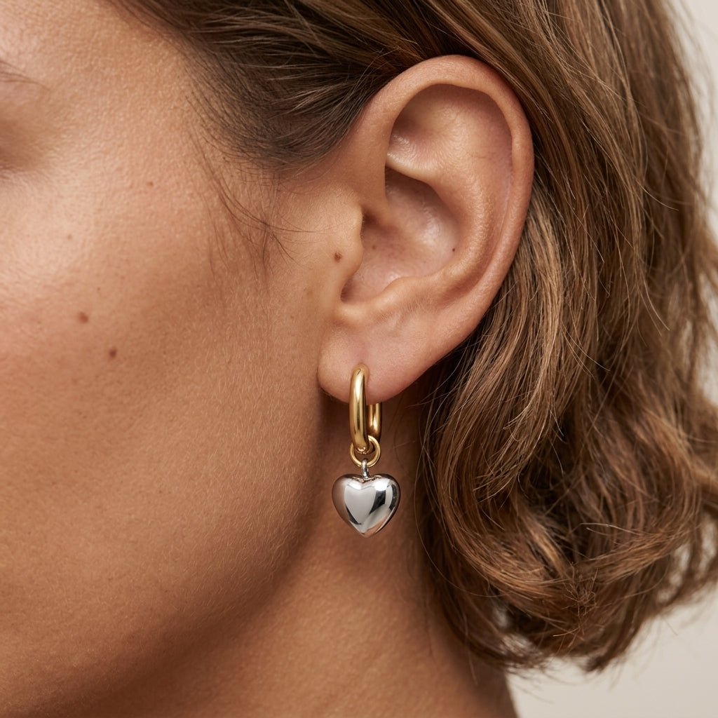gold and silver heart earrings with a polished mixed metal design