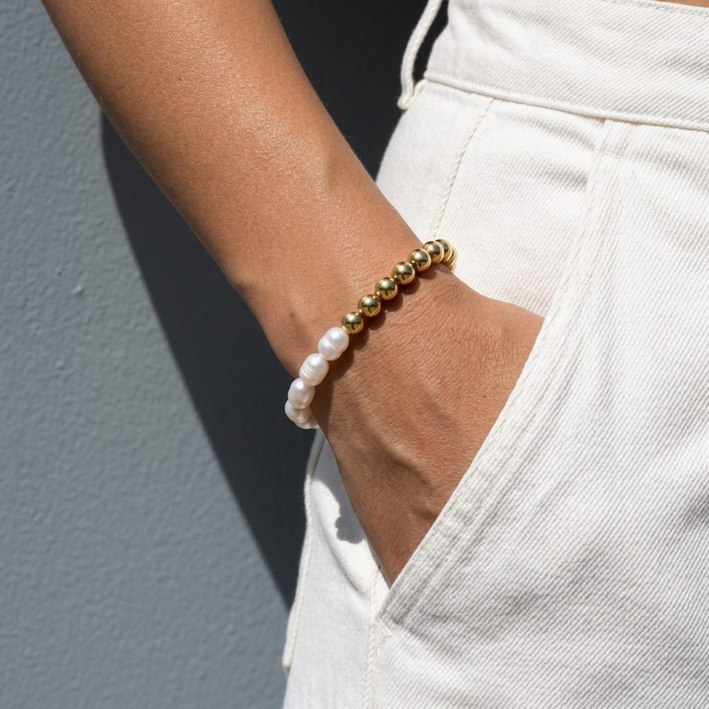 gold bead pearl bracelet with polished round gold beads and white pearls worn on the wrist