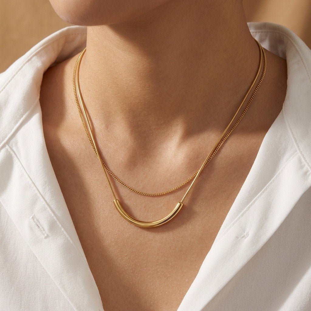 gold layered curve necklace with a modern curved centerpiece and delicate chain design