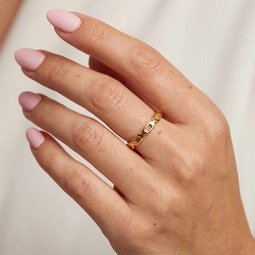 gold link ring with repeating open links and a polished geometric design
